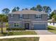 Two-story home with well-maintained landscaping, a stone-accented entrance, and a paved driveway at 524 Avila Pl, Howey In The Hills, FL 34737
