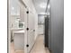 Hallway leading to kitchen and laundry area with gray cabinets and stainless steel refrigerator at 524 Avila Pl, Howey In The Hills, FL 34737