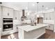Modern kitchen featuring white cabinets, a large island, stainless steel appliances, and ample lighting at 524 Avila Pl, Howey In The Hills, FL 34737