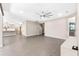 Open living room with modern ceiling fan, wood-look tile floors, and seamless flow to the kitchen at 524 Avila Pl, Howey In The Hills, FL 34737