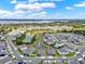Aerial view of a residential community with waterfront views and lush green landscaping on a partly cloudy day at 533 Avila Pl, Howey In The Hills, FL 34737