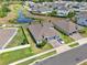 Aerial view of home with pond in backyard and three-car garage at 533 Avila Pl, Howey In The Hills, FL 34737