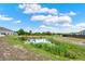 View of backyard with pond and green foliage separating properties at 533 Avila Pl, Howey In The Hills, FL 34737