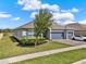 Single Gathering home with a three car garage, landscaped yard, and a partial lake view at 533 Avila Pl, Howey In The Hills, FL 34737
