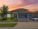 Beautiful single Gathering home with a three car garage, landscaped yard and warm sunset at 533 Avila Pl, Howey In The Hills, FL 34737