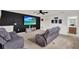 Comfortable living room with ceiling fan, tv, reclining chairs, and adjacent entryway at 533 Avila Pl, Howey In The Hills, FL 34737
