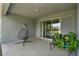 Open patio with hanging chair, outdoor seating, and view to inside through sliding glass door at 533 Avila Pl, Howey In The Hills, FL 34737