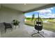 Covered patio overlooking green space with a hanging chair and outdoor seating at 533 Avila Pl, Howey In The Hills, FL 34737