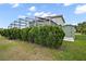 Backyard view of shrubbery in front of enclosed pool, yard and small outdoor storage shed at 54 Andora Ct, Kissimmee, FL 34758