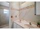Bright bathroom with double vanity, marble countertops, and a glass-enclosed shower at 54 Andora Ct, Kissimmee, FL 34758