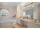 This bathroom features a soaking tub, a makeup vanity, and double sinks at 54 Andora Ct, Kissimmee, FL 34758