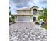 Two-story home features manicured landscaping, an arched entryway, and a large garage at 54 Andora Ct, Kissimmee, FL 34758