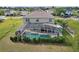 Aerial view of home's enclosed pool, yard and lush green foliage at 54 Andora Ct, Kissimmee, FL 34758