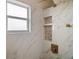 This shower features marble tiling, gold hardware, and built-in shelving at 54 Andora Ct, Kissimmee, FL 34758