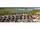An aerial view shows the homes and the landscape with a lake at 648 Mission Hills Trl, The Villages, FL 32162