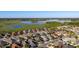An aerial view shows the homes and the landscape with a lake at 648 Mission Hills Trl, The Villages, FL 32162