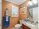 Well-maintained bathroom with a granite countertop, decorative shelves, and blue and white accents at 648 Mission Hills Trl, The Villages, FL 32162