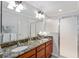 Bathroom with granite countertops, a double sink vanity, framed mirrors, and a glass door walk-in shower at 648 Mission Hills Trl, The Villages, FL 32162