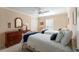 Cozy bedroom featuring twin beds, neutral walls with crown molding, and a dresser with a decorative mirror at 648 Mission Hills Trl, The Villages, FL 32162