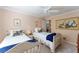 Comfortable bedroom with two twin beds, a ceiling fan, and neutral walls with decorative artwork at 648 Mission Hills Trl, The Villages, FL 32162