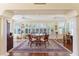 Sunlit dining area with large windows, plantation shutters, ceiling fans, and hardwood floors at 648 Mission Hills Trl, The Villages, FL 32162