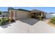Charming home featuring a well-manicured lawn, neutral stucco, and a two-car garage with an extended, patterned concrete driveway at 648 Mission Hills Trl, The Villages, FL 32162