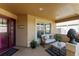 Cozy front porch with comfortable seating, decorative plants, and neutral walls at 648 Mission Hills Trl, The Villages, FL 32162