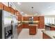 Spacious kitchen features stainless steel appliances, granite countertops, and wood cabinets at 648 Mission Hills Trl, The Villages, FL 32162
