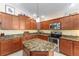 Updated kitchen with granite countertops, stainless steel appliances, and wood cabinets at 648 Mission Hills Trl, The Villages, FL 32162