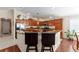 Well-lit kitchen with granite countertops, wood cabinets, and stainless steel appliances at 648 Mission Hills Trl, The Villages, FL 32162