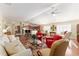 Bright living room featuring a ceiling fan, hardwood floors, and open layout to the kitchen and dining area at 648 Mission Hills Trl, The Villages, FL 32162