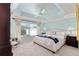 Serene main bedroom featuring a decorative tray ceiling, plush carpeting, and ample natural light at 648 Mission Hills Trl, The Villages, FL 32162