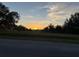 Exterior view of home at sunset showcases expansive land and landscaping at 6619 Ona Ct, Clermont, FL 34714