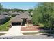 Aerial view of a well-maintained single-story home featuring a two-car garage and landscaped front yard at 6942 Sw 94Th Ct, Ocala, FL 34481