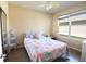 Cozy bedroom featuring a comfortable bed with floral patterns, side table, a window, and natural light at 6942 Sw 94Th Ct, Ocala, FL 34481