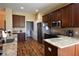 Modern kitchen featuring stainless steel appliances, granite countertops, and dark wood cabinets at 6942 Sw 94Th Ct, Ocala, FL 34481