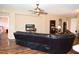 Comfortable living room featuring a leather sectional sofa, ceiling fan, and view into an adjacent room at 6942 Sw 94Th Ct, Ocala, FL 34481