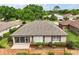 Aerial view showcasing the home's roof, screened-in lanai, and manicured landscaping at 7034 Pine Hollow Dr, Mount Dora, FL 32757
