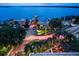 Stunning aerial view of lakefront homes with a private dock and an outdoor restaurant with string lights at 7034 Pine Hollow Dr, Mount Dora, FL 32757