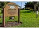 A sign for Burton Park with the words 'Welcome' and the Country Club of Mount Dora, surrounded by green grass at 7034 Pine Hollow Dr, Mount Dora, FL 32757