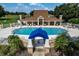 Beautiful community pool with clubhouse, surrounded by lush landscaping and comfortable lounge seating at 7034 Pine Hollow Dr, Mount Dora, FL 32757