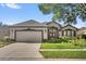 Charming single-story home featuring a two-car garage, well-maintained landscaping, and a welcoming front entrance at 7034 Pine Hollow Dr, Mount Dora, FL 32757