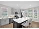 Modern kitchen with gray cabinets, stainless steel appliances, a center island, and ample natural light at 7034 Pine Hollow Dr, Mount Dora, FL 32757