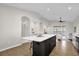 Open-concept kitchen boasting a large center island, modern appliances, seamless flow to the living areas at 7034 Pine Hollow Dr, Mount Dora, FL 32757