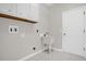 Bright laundry room with overhead cabinets, white utility sink and tile flooring at 7034 Pine Hollow Dr, Mount Dora, FL 32757