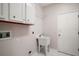 Functional laundry room includes a utility sink, storage cabinets, and a tiled floor at 7034 Pine Hollow Dr, Mount Dora, FL 32757