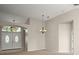 Spacious living room with neutral paint and chandelier, view of front doors and arched window at 7034 Pine Hollow Dr, Mount Dora, FL 32757