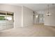 Spacious living room with neutral carpet, a chandelier, and sliding glass doors to a screened patio at 7034 Pine Hollow Dr, Mount Dora, FL 32757