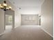 Bright, spacious living room with neutral carpeting, a chandelier, large window, and views of other rooms at 7034 Pine Hollow Dr, Mount Dora, FL 32757