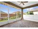 Enclosed patio featuring brick flooring, ample natural light, and a ceiling fan at 7034 Pine Hollow Dr, Mount Dora, FL 32757